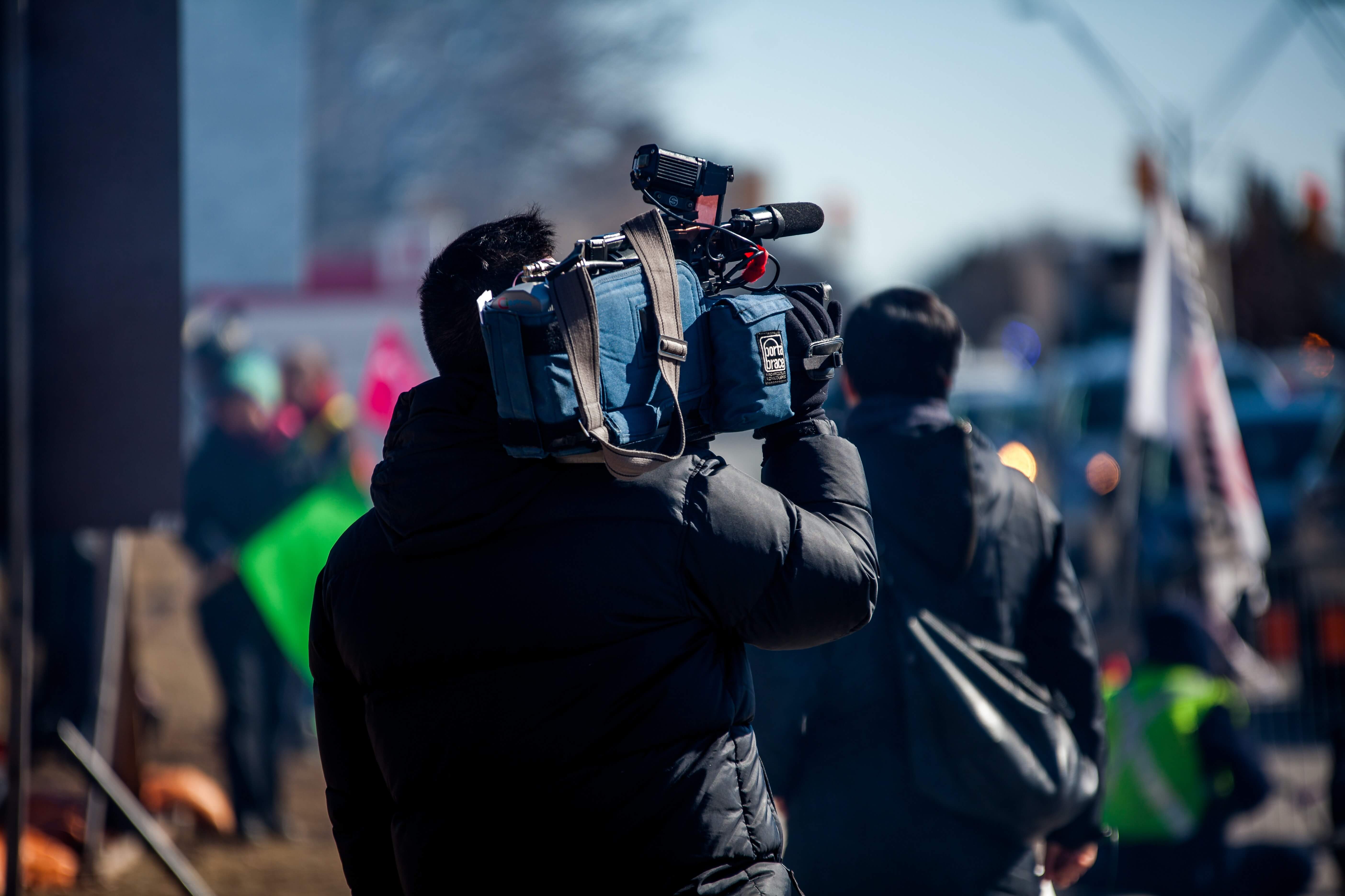 ITV Case Study - Camera man A man holding a TV camera