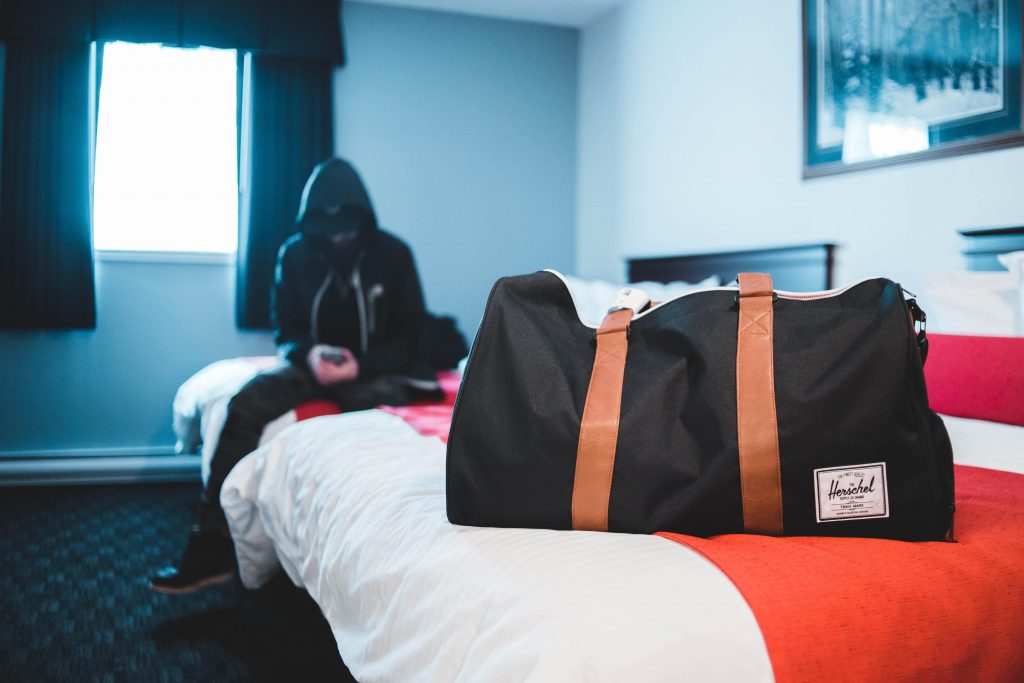 Person sat on the bed with bag packed
